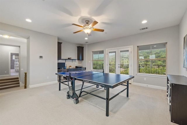 recreation room with french doors, light colored carpet, and ceiling fan