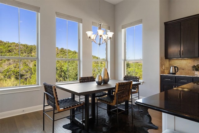 dining space featuring an inviting chandelier and dark wood-type flooring