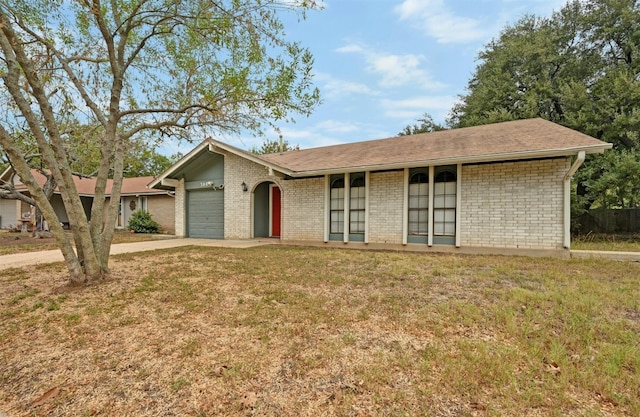 single story home featuring a garage and a front lawn