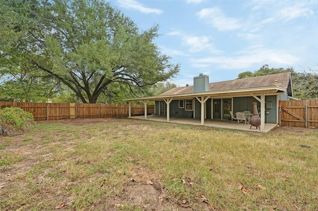 back of property with a yard and a patio