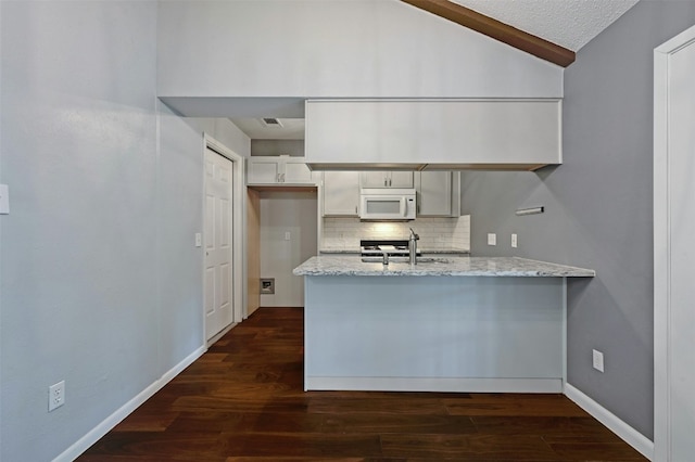 kitchen featuring lofted ceiling, sink, light stone countertops, and dark hardwood / wood-style floors