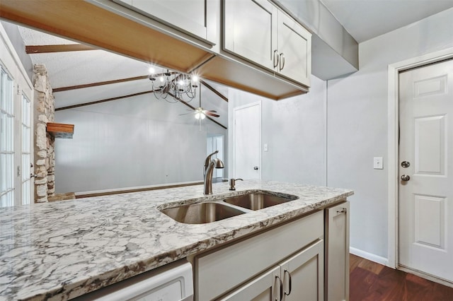 kitchen with sink, vaulted ceiling, dark hardwood / wood-style flooring, dishwasher, and light stone countertops