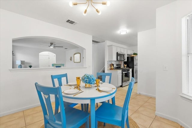 311 Juniper Dr, Georgetown, TX 78626 - dining space featuring arched walkways, ceiling fan with notable chandelier, baseboards, light tile patterned floors, and visible vents