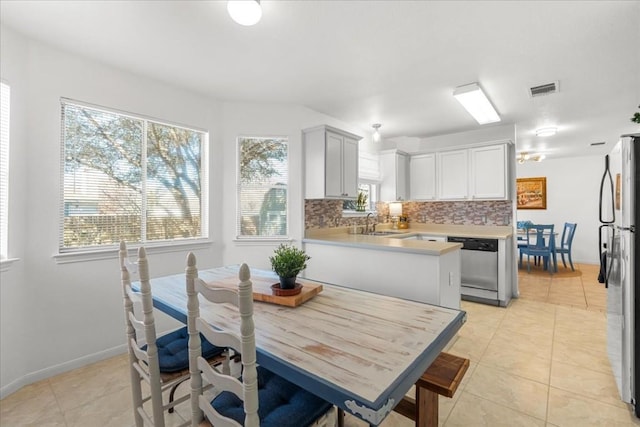 dining area featuring sink and light tile patterned floors