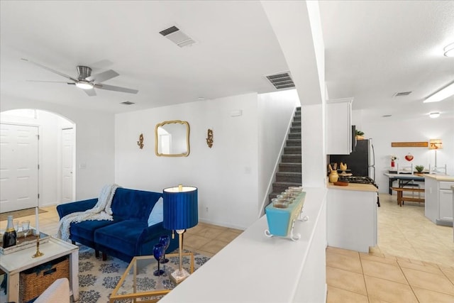 living room featuring light tile patterned floors and ceiling fan