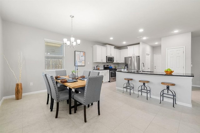 tiled dining space featuring an inviting chandelier and sink