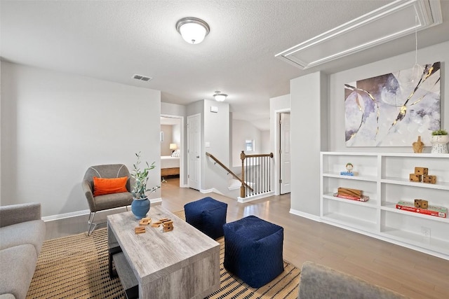 living room with a textured ceiling and light wood-type flooring