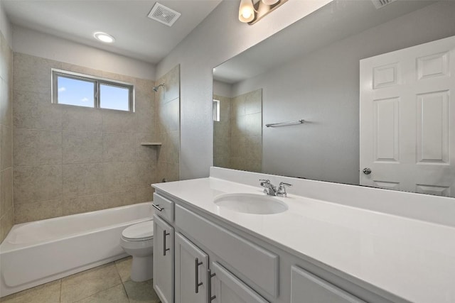 full bathroom with tile patterned floors, toilet, tiled shower / bath combo, and vanity