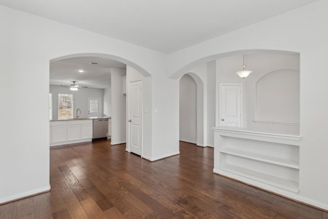 unfurnished room featuring ceiling fan, dark hardwood / wood-style floors, and sink