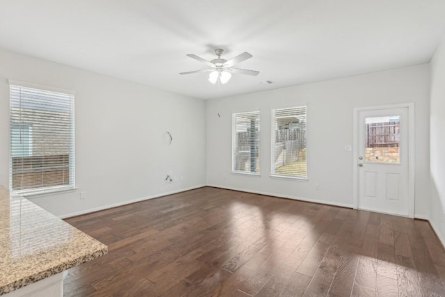 interior space with dark wood-type flooring and ceiling fan