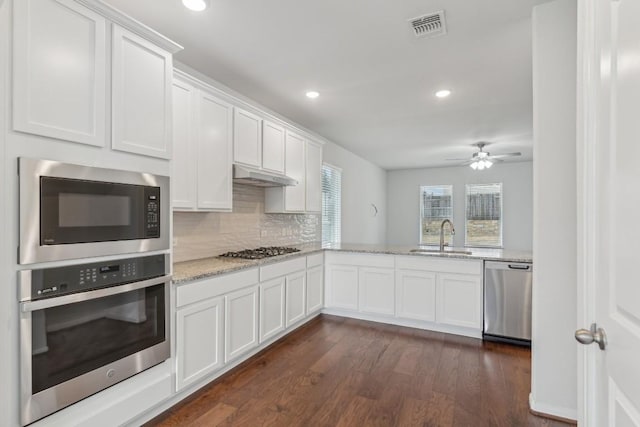 kitchen featuring light stone counters, sink, white cabinets, and appliances with stainless steel finishes