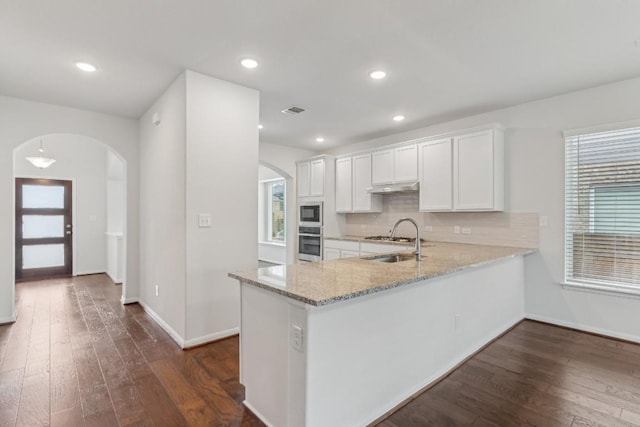 kitchen featuring sink, white cabinetry, kitchen peninsula, dark hardwood / wood-style flooring, and oven