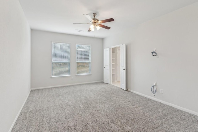 unfurnished room with ceiling fan and carpet