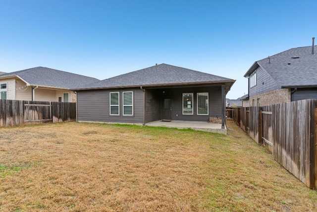 rear view of property with a yard and a patio