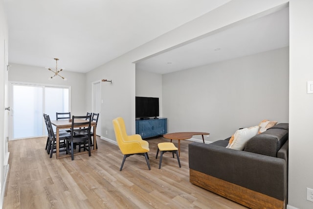 living room featuring a chandelier and light hardwood / wood-style flooring