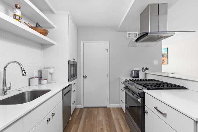 kitchen with stainless steel appliances, white cabinetry, and exhaust hood