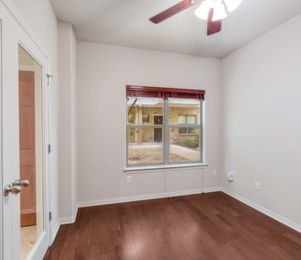 spare room featuring dark wood-type flooring and ceiling fan