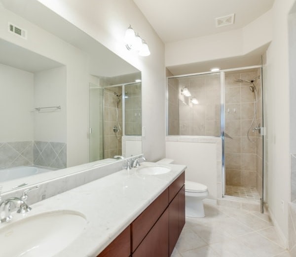 bathroom with vanity, tile patterned floors, toilet, and walk in shower