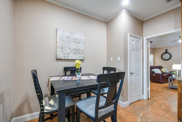 dining space featuring ceiling fan and ornamental molding