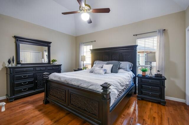 bedroom featuring dark hardwood / wood-style flooring, ceiling fan, and vaulted ceiling