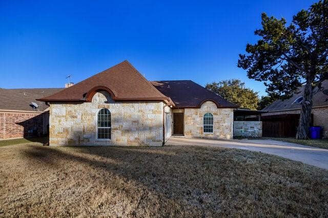 french country inspired facade with a front yard