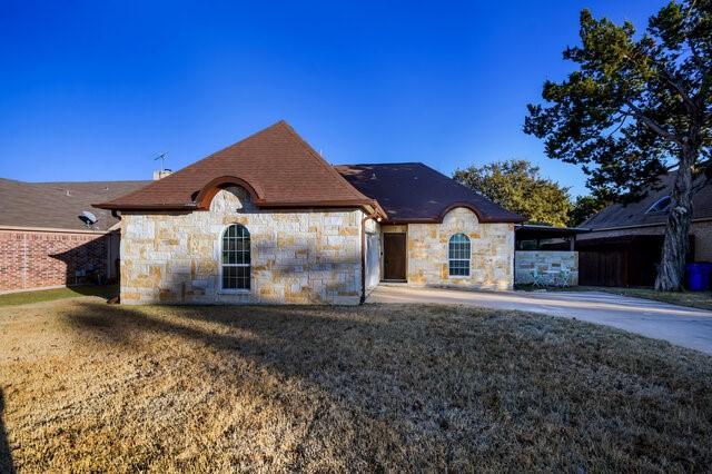 french provincial home with a front lawn