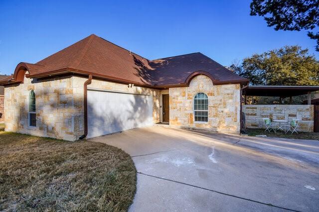 view of front of property featuring a garage, a carport, and a front yard