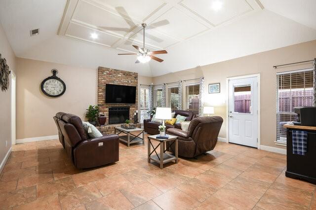 living room featuring coffered ceiling, ceiling fan, and a fireplace