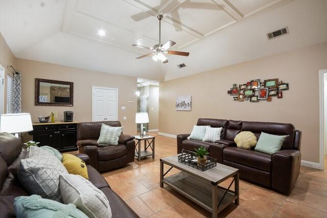 living room with coffered ceiling, lofted ceiling, and ceiling fan