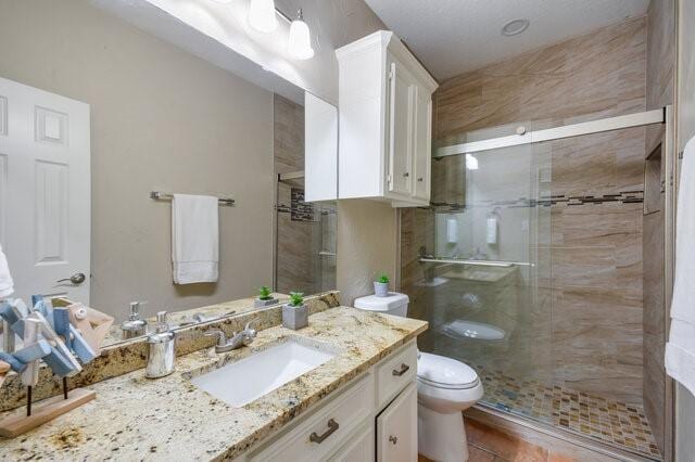 bathroom featuring vanity, toilet, and walk in shower