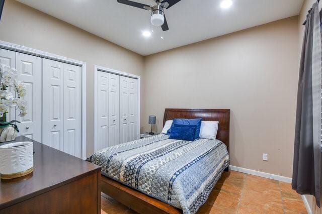 bedroom with ceiling fan and multiple closets