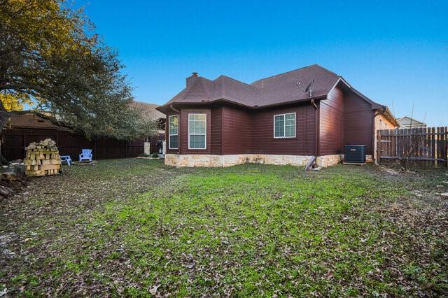 view of side of home featuring central AC unit and a lawn