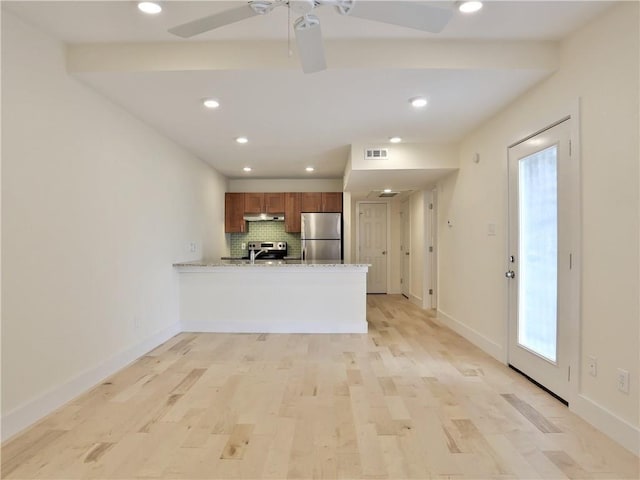 kitchen featuring stainless steel appliances, backsplash, light wood-type flooring, and kitchen peninsula