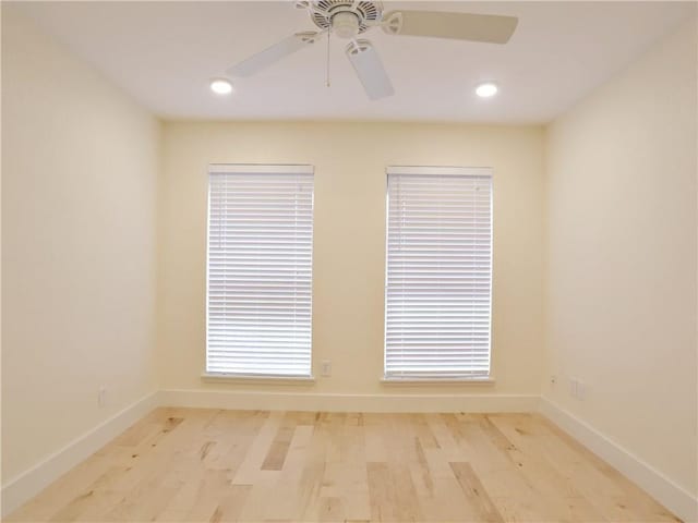 empty room with ceiling fan and light hardwood / wood-style floors