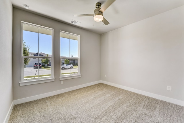 carpeted spare room with ceiling fan