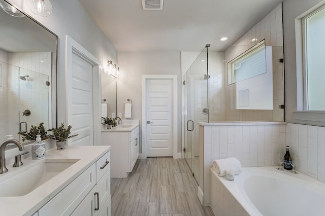 bathroom with vanity, separate shower and tub, and a wealth of natural light