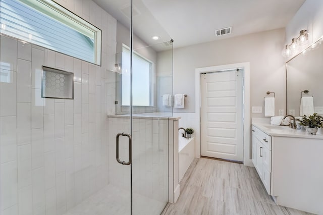 bathroom with vanity, hardwood / wood-style floors, and independent shower and bath