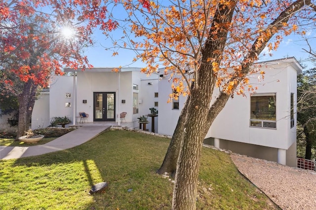 view of front facade with a front yard and french doors