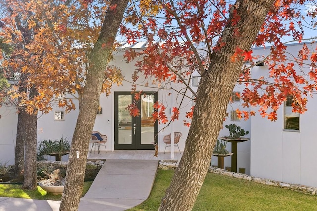 entrance to property with a lawn and french doors