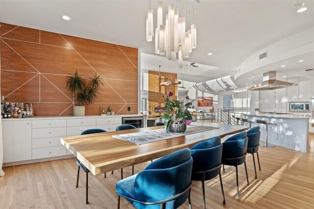 2102 N Oak Canyon Rd, Austin, TX 78746 - dining room featuring light wood-type flooring, recessed lighting, beverage cooler, and a bar