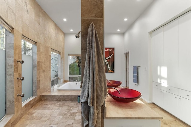 2102 N Oak Canyon Rd, Austin, TX 78746 - full bath featuring a garden tub, recessed lighting, a tile shower, vanity, and stone finish floors