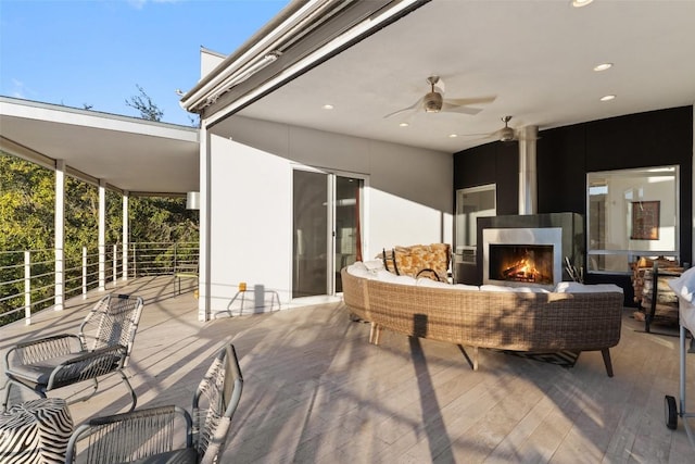 view of patio featuring ceiling fan and an outdoor living space with a fireplace