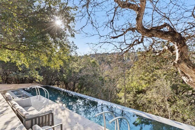 2102 N Oak Canyon Rd, Austin, TX 78746 - outdoor pool featuring a wooded view