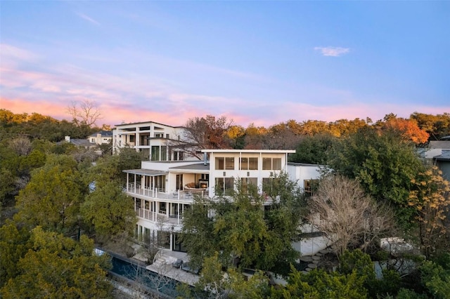 back house at dusk with a balcony