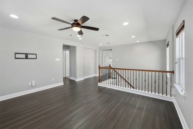 empty room featuring dark wood-type flooring and ceiling fan