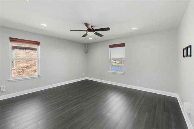 empty room with ceiling fan, dark hardwood / wood-style floors, and a healthy amount of sunlight