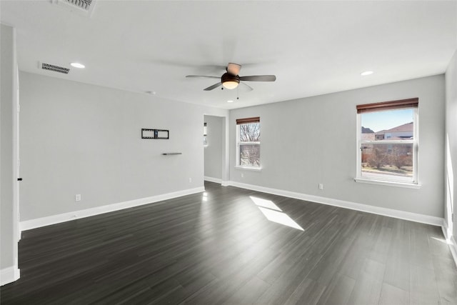 spare room with plenty of natural light, dark hardwood / wood-style floors, and ceiling fan