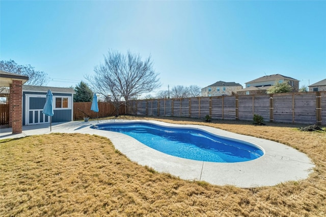 view of swimming pool featuring a shed and a yard