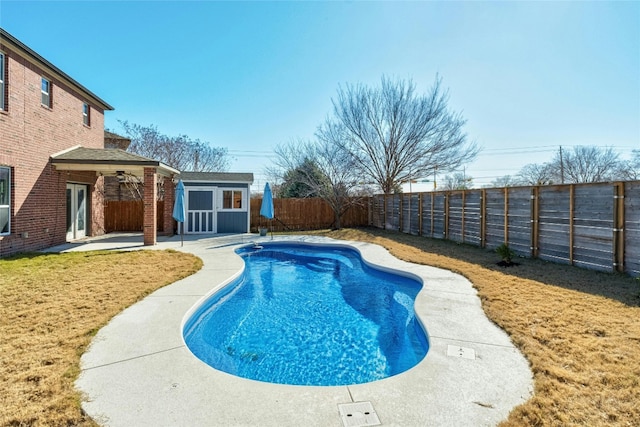 view of swimming pool with a yard, an outbuilding, and a patio area