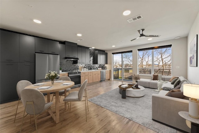 living room featuring light hardwood / wood-style floors and ceiling fan